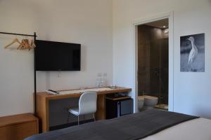 a bedroom with a bed and a desk with a computer at Bio Agriturismo Corte degli Ulivi in Grosseto