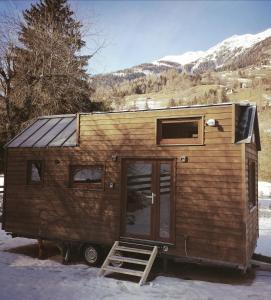 ein winziges Haus mit einer Tür im Schnee in der Unterkunft Tiny House Waldschmied 2 