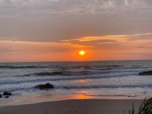 a sunset on the beach with the ocean at Bờ Biển Vàng Hotel in Ke Ga