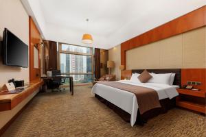 um quarto de hotel com uma cama grande e uma secretária em Vanburgh Hotel - Free shuttle bus transfer during Canton Fair em Guangzhou