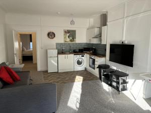 a living room with a kitchen with a washing machine at Urban Heights, Central BH1 in Bournemouth