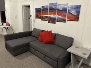 a living room with a gray couch with a red pillow at Urban Heights, Central BH1 in Bournemouth