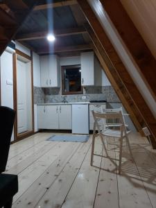 a kitchen with white cabinets and a chair in it at Vip Villa Jagodina in Jagodina