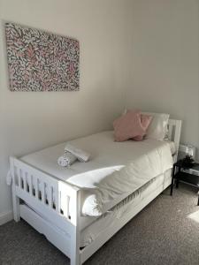 a white bed in a bedroom with a painting on the wall at Urban Heights, Central BH1 in Bournemouth