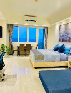 a bedroom with two beds and a dining room with a table at Sophisticated Oceanview Studio in La Mirada in Mactan