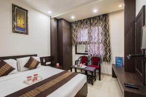 Habitación de hotel con cama y silla en Hotel Joy en Jaipur
