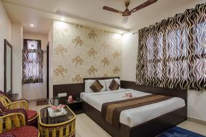 Habitación de hotel con cama y silla en Hotel Joy en Jaipur