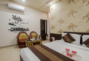 Habitación de hotel con 1 cama y 2 sillas en Hotel Joy en Jaipur