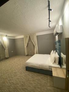 a bedroom with a large bed and curtains at أجنحة هدوء الفندقية in Riyadh