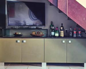 un televisor sentado en la parte superior de un mostrador con botellas de vino en Flat Winterville 314, en Gravatá