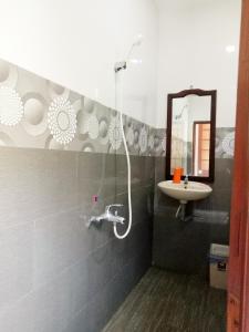 une salle de bain avec douche et lavabo dans l'établissement Suối Nước Resort, à Ấp Long Sơn