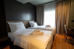 duas camas num quarto de hotel com uma janela em Arka Art Hotel em Tirana