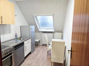 cocina con fregadero, mesa y ventana en Work & Stay Leverkusen en Leverkusen