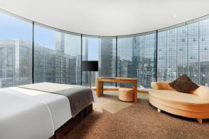 1 dormitorio con cama, silla y ventana grande en Vanburgh Hotel - Free shuttle bus transfer during Canton Fair en Guangzhou