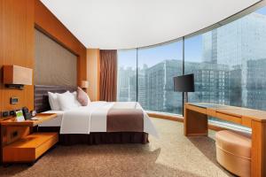 um quarto de hotel com uma cama e uma grande janela em Vanburgh Hotel - Free shuttle bus transfer during Canton Fair em Guangzhou