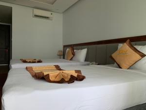 科嘎的住宿－Bờ Biển Vàng Hotel，配有白色床单的酒店客房内的两张床