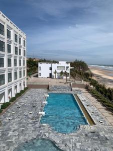 een uitzicht over een zwembad naast een gebouw en het strand bij Bờ Biển Vàng Hotel in Ke Ga