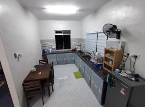 eine Küche mit einem Tisch und einer Arbeitsplatte in der Unterkunft Homestay Schemumarc in Arau