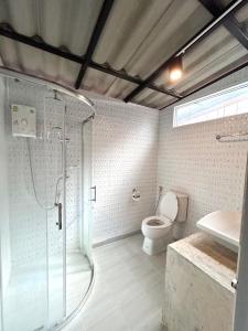 a bathroom with a shower and a toilet and a sink at บ้านมาดามกรีน Baan Madamn Green Nan in Nan