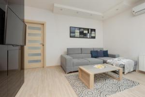 a living room with a couch and a table at Woronicza Apartment with Balcony In Warsaw's Mokotów by Renters in Warsaw