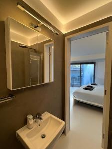 a bathroom with a sink and a mirror and a bed at Casa Olmi in Shoreditch in London