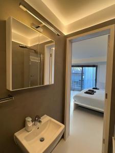 a bathroom with a sink and a mirror and a bed at Casa Olmi in Shoreditch in London