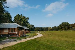 a gazebo in a field next to a path at Glamping lodge with Eco-Wellness in Zeewolde