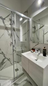 a white bathroom with a shower and a sink at Suitedream Vatican in Rome