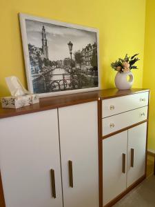 a dresser with a picture on top of it at Privatzimmer mit Balkon in Munich