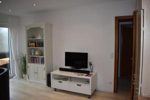 a living room with a tv on a white cabinet at Ferienwohnung (H)Auszeit Pape in Winterberg