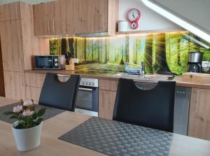 a kitchen with a table with two chairs and a sink at Ferienwohnung (H)Auszeit Pape in Winterberg