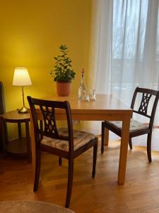 una mesa de madera con 2 sillas y una mesa con una planta en Privatzimmer mit Balkon, en Múnich