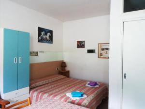 サン・ヴィート・ディ・カドーレにあるAppartamenti Codànのベッドルーム1室(ベッド2台、青いキャビネット付)