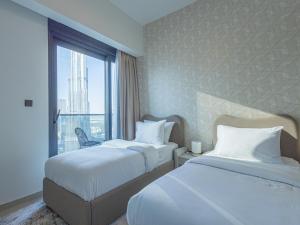 Habitación de hotel con 2 camas y ventana en MH- Act - Burj View 3BHK-REF4008 en Dubái