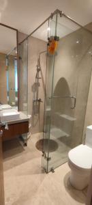 a bathroom with a shower and a toilet and a sink at Villa Bahenol Puncak in Paragajen