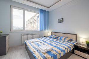 a bedroom with a bed with blue walls and windows at Lovely 2 BDR suite next to Mall of Sofia in Sofia