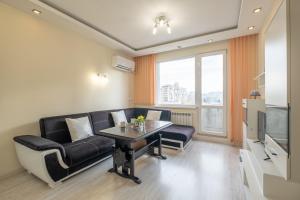a living room with a couch and a table at Lovely 2 BDR suite next to Mall of Sofia in Sofia