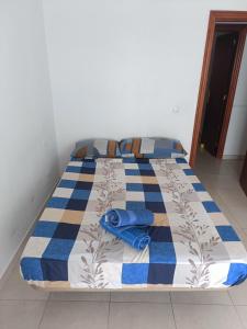 a bed with a blue and white quilt on it at Appartement vista mar in Puerto del Rosario