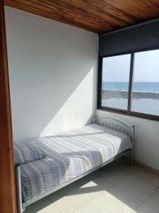a bed in a room with a view of the ocean at Appartement vista mar in Puerto del Rosario