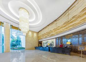 een lobby van een hotel met een groot plafond bij Vanburgh Hotel - Free shuttle bus transfer during Canton Fair in Guangzhou