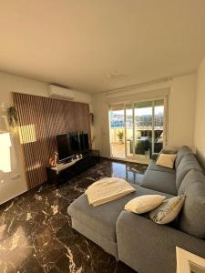 a living room with a couch and a television at VCS Carvajal - Modern and cozy apartment close to the beach! in Fuengirola