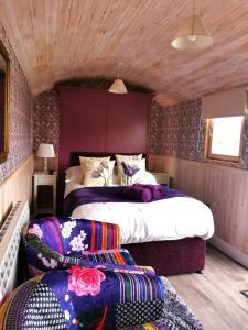 a bedroom with two beds and two ottomans at Shepherd's Hut at Cefn Tilla Court in Usk