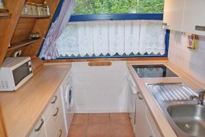 a small kitchen with a sink and a microwave at Zeltdachhaus mit Kamin und grosser Terrasse in Damp