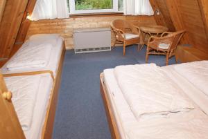 a room with two beds and a table and chairs at Zeltdachhaus mit Kamin und grosser Terrasse in Damp +5 photos