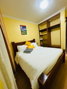 - une chambre avec un grand lit et des draps blancs dans l'établissement Lovely 2 Bedroom Apartment in Ongata Rongai, à Langata Rongai