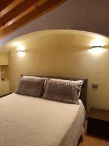 um quarto com uma cama branca e 2 almofadas em Casa Amalia em Bardolino