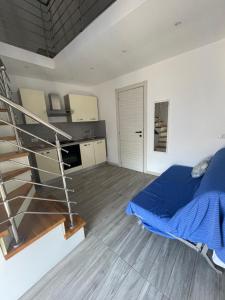 a bedroom with a blue bed and a spiral staircase at Specchio Marino in Ponza