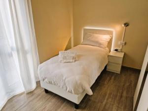 um quarto com uma cama com lençóis brancos e almofadas em La Corte del Maggiore em Parma