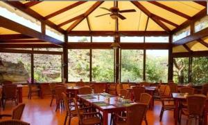 - une salle à manger avec des tables, des chaises et des fenêtres dans l'établissement Jalsa inn, Bhopal, à Shamsgarh