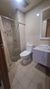 a bathroom with a toilet and a shower and a sink at Oowa's Residence in Jatirarangan